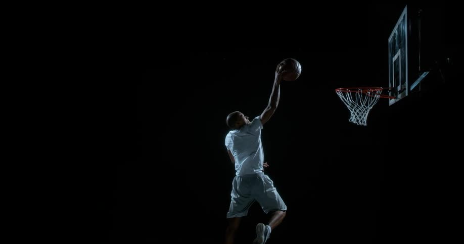 Man runs up with a basketball and dunks it