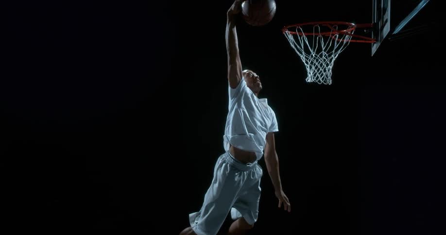 A man is dunking a basketball