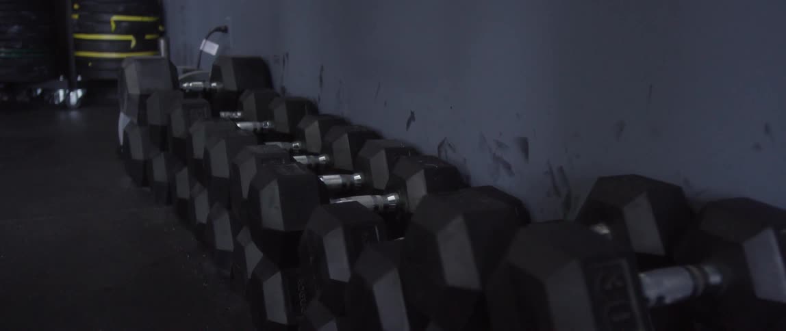 Heavy dumbbells stacked against a wall