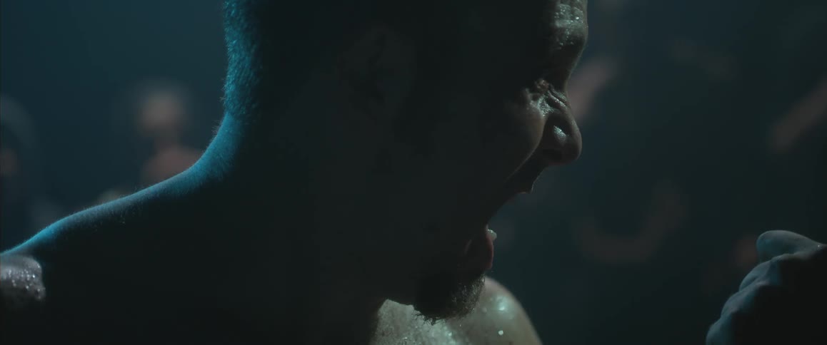 Sweaty man in a dark room gets punched in the face