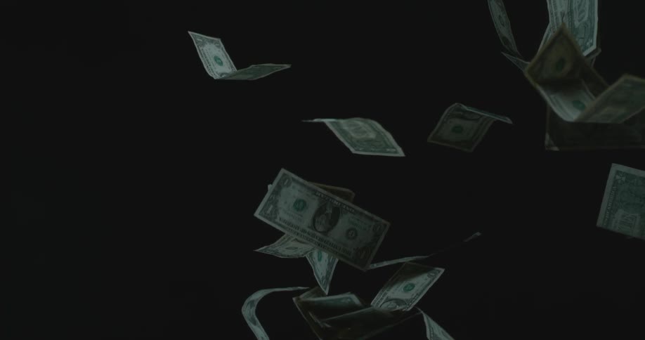 Money flying in the air in a dark area