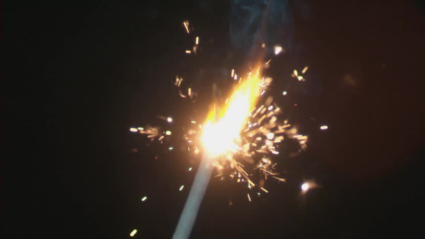 A sparkly slowly burning down in a dark area