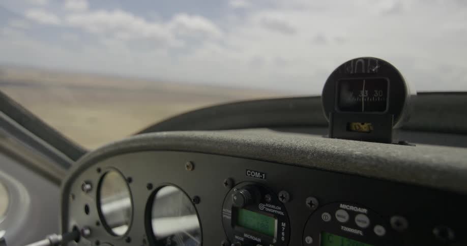 A small airplane flies over a rural area