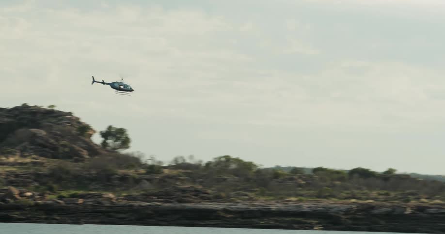 Helicopter flying low over a pool of water