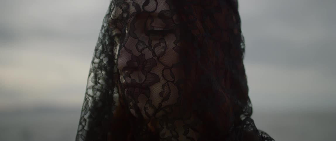 A woman grieves wearing black lace