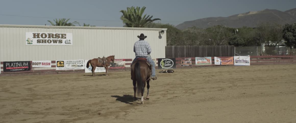A man rides his horse over to a building
