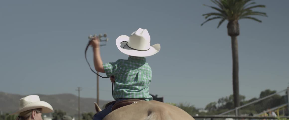 A child practices with a rope on horseback