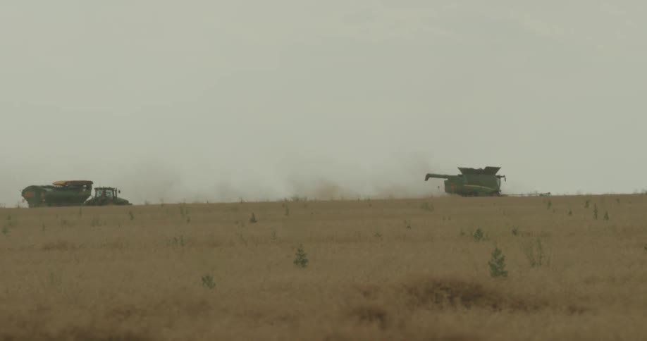 Farm equipment works the land during the day
