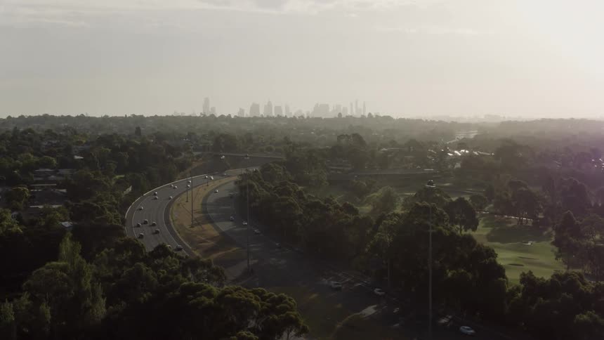 A highway through a city full of trees