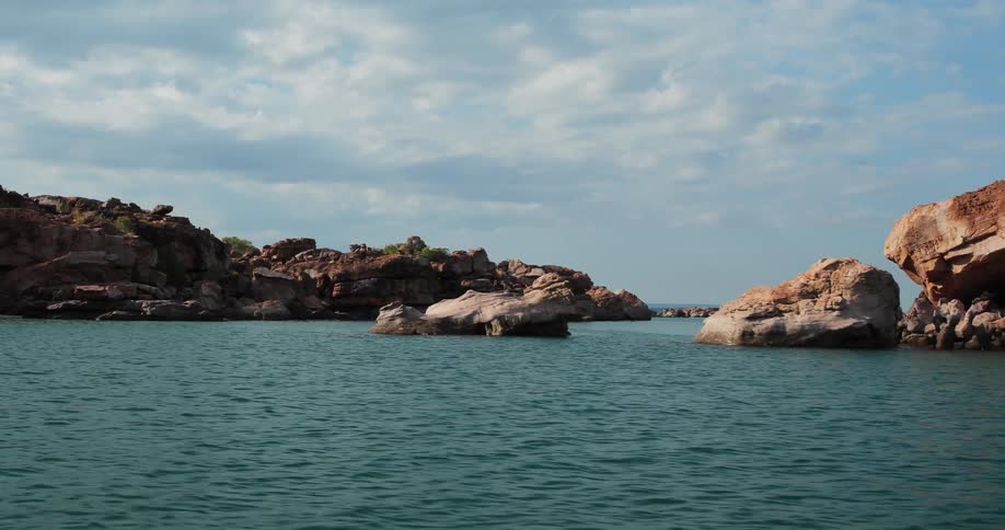 Rock formations sit in a large body of water
