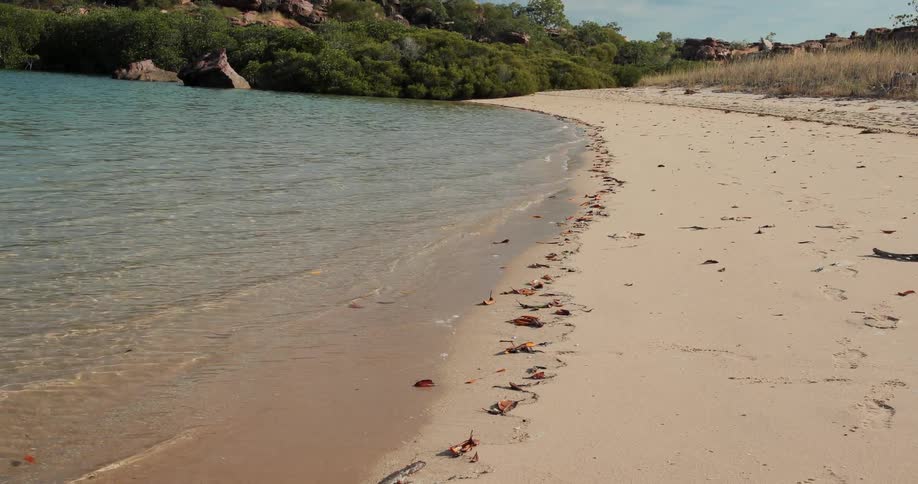 Blue water flows towards the sandy shore
