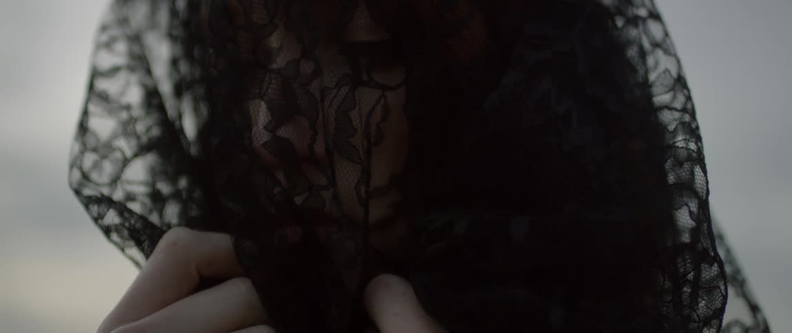 A woman wears a black veil over her face