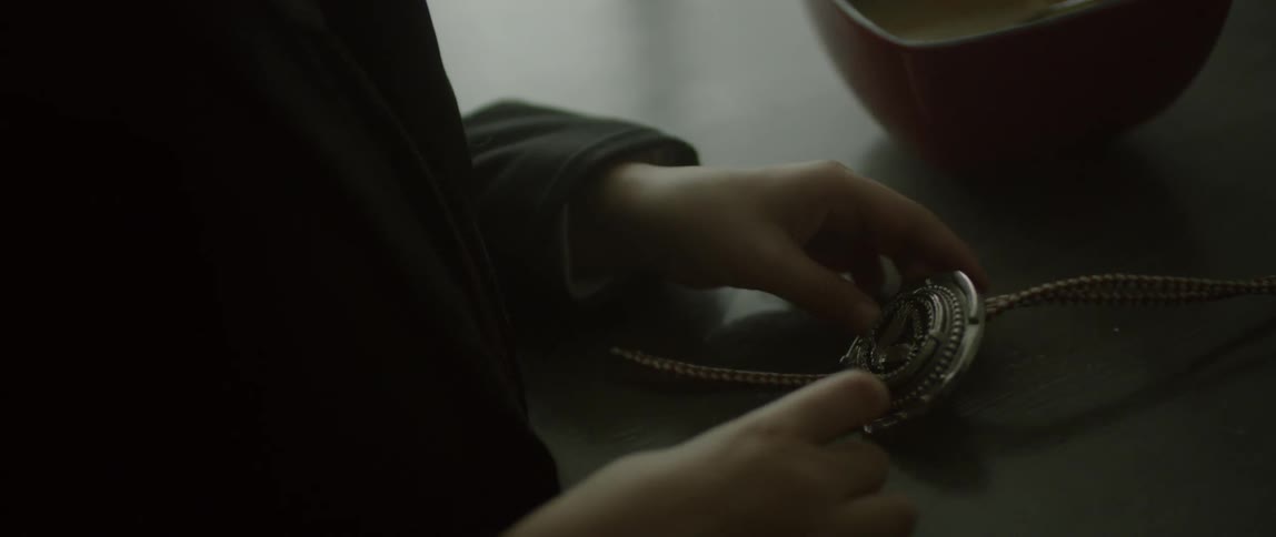 A young boy holds a medallion in his hands