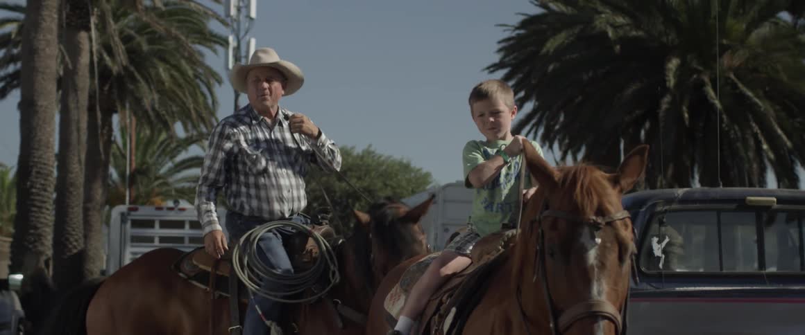 Man and boy ride horses