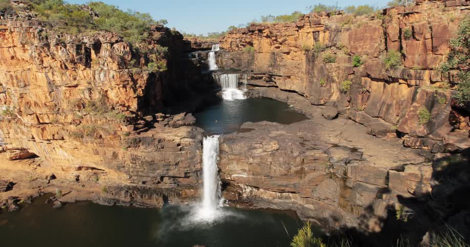 Waterfall splashing down a cliff into a pool and down another cliff