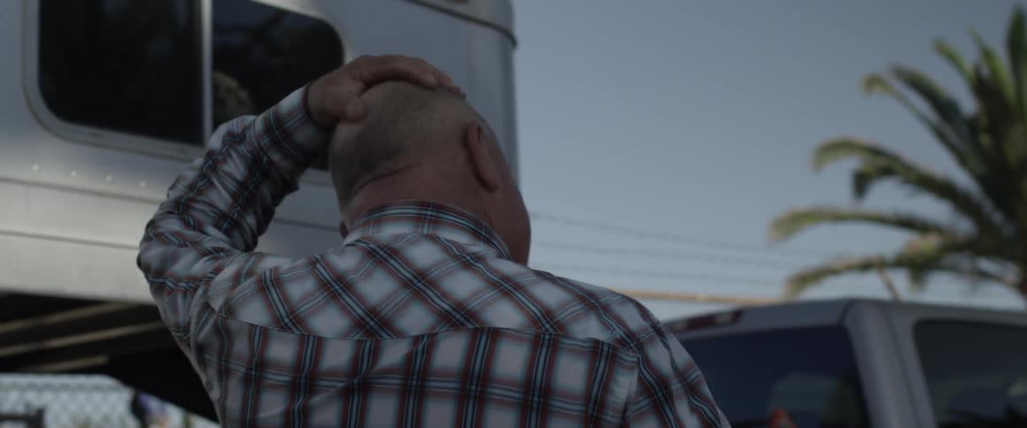 A man removes his cowboy hat