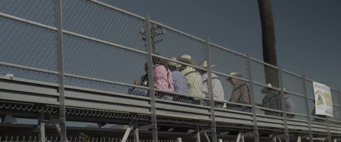 People sit in the stands at an open air stadium