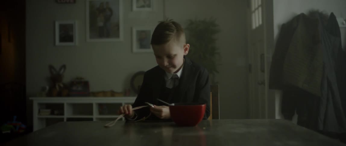 A boy is looking at an item with a string