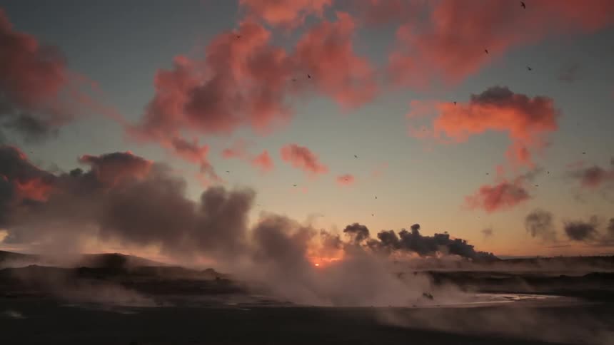 Birds fly in the sky above steaming water