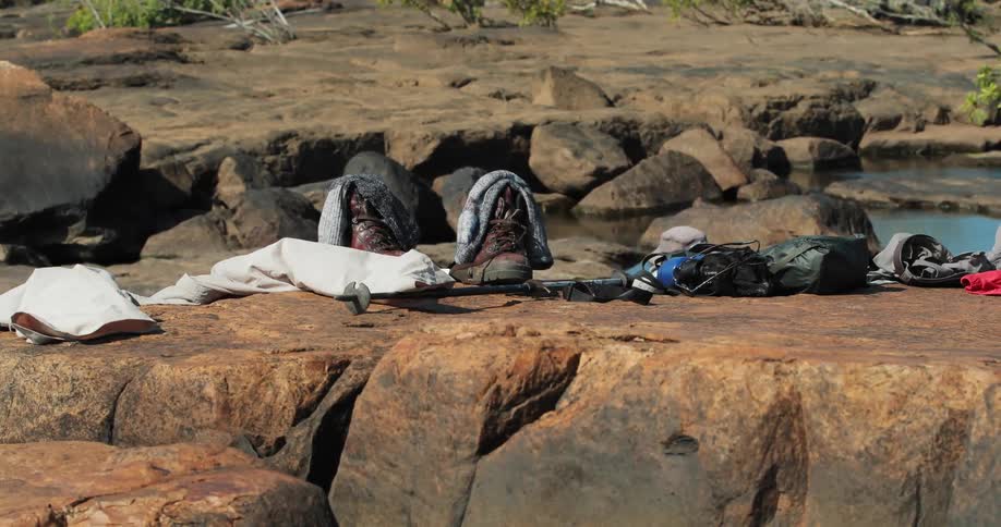 Shoes and socks on top of large rocks