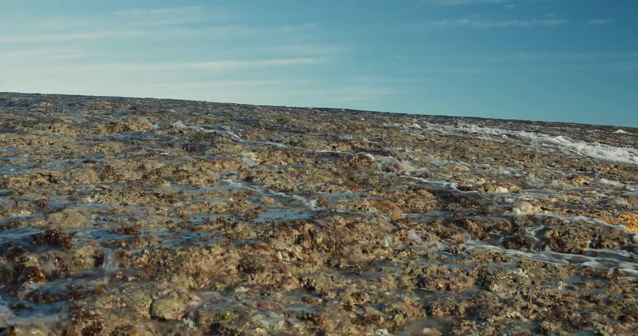 Water is rushing down a wide, rocky surface