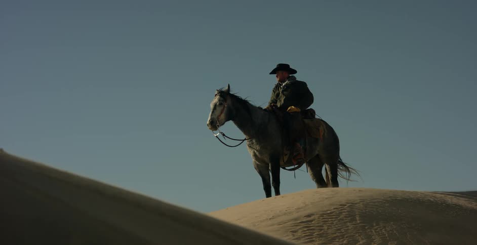 A man is on his horse on a windy day