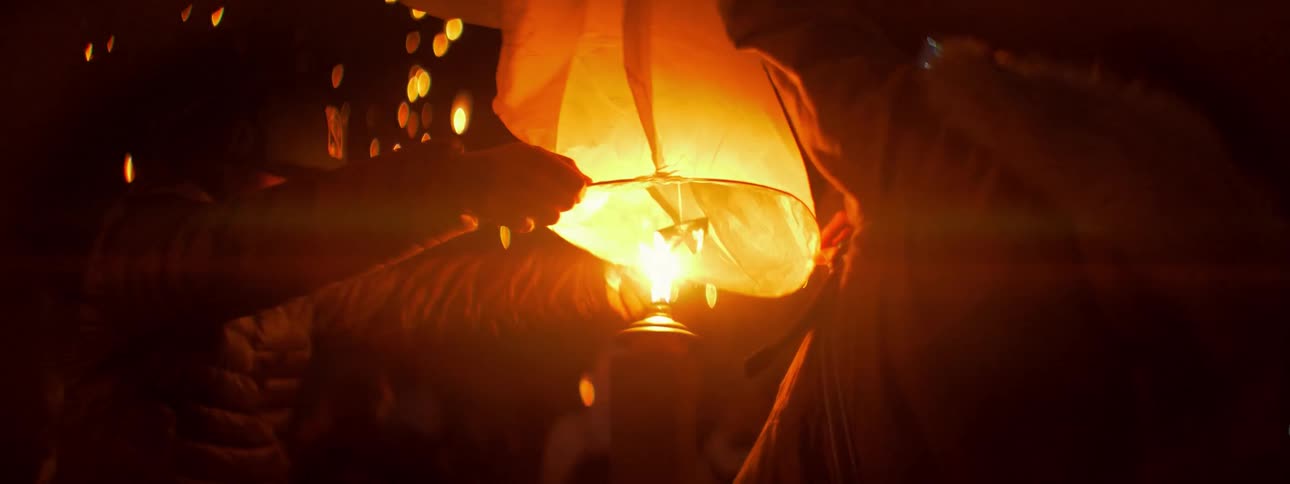 People firing up chinese lanterns at night