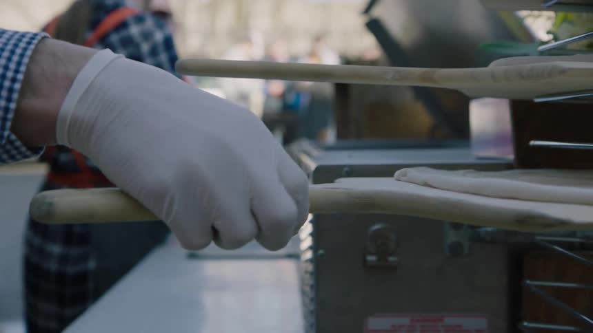 A person puts dough on a rack