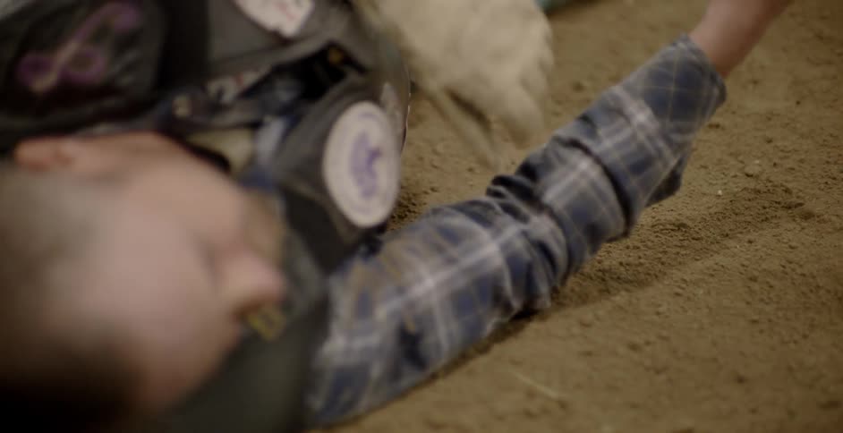 A rodeo cowboy flops as he hits the dirt