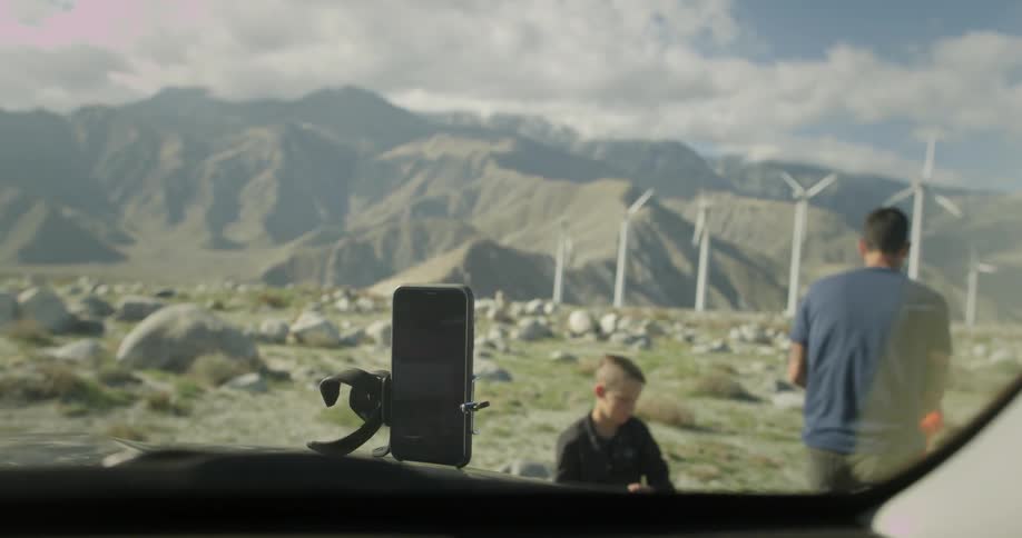 A man places a phone on a stand and walks off with his children