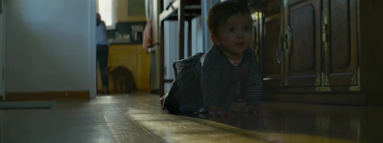 A child is crawling down the hall