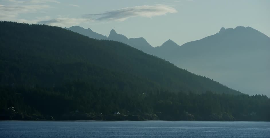The water is calm near the mountain