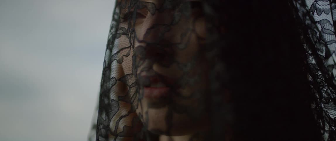 A woman grieves wearing black lace