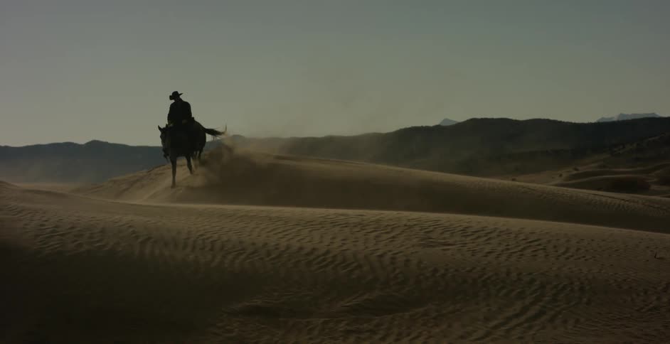 A man rides his horse in the desert