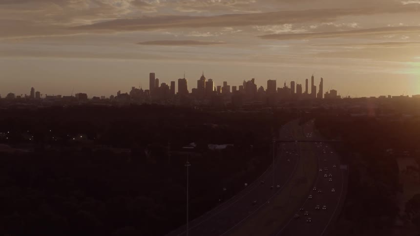 The sun sets over city skyscrapers