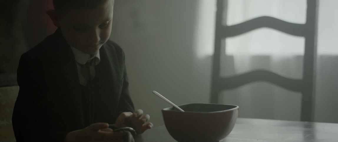 A child looks at an item at a kitchen table