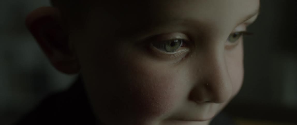 A green-eyed child bites his lip
