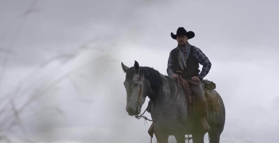 A man sits on a horse on a cloudy day