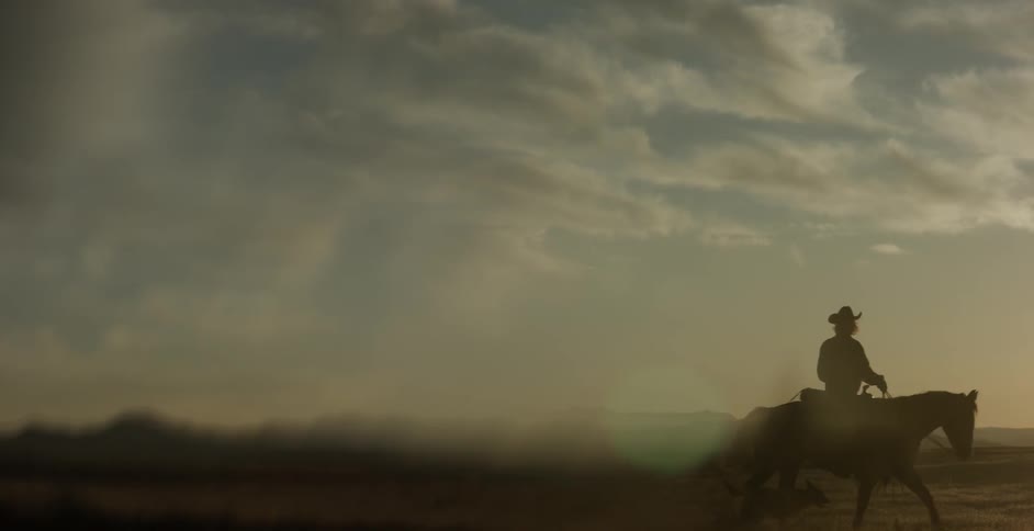 A man is riding his horse on a cloudy day