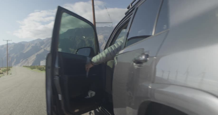 A man enters the driver side of an suv
