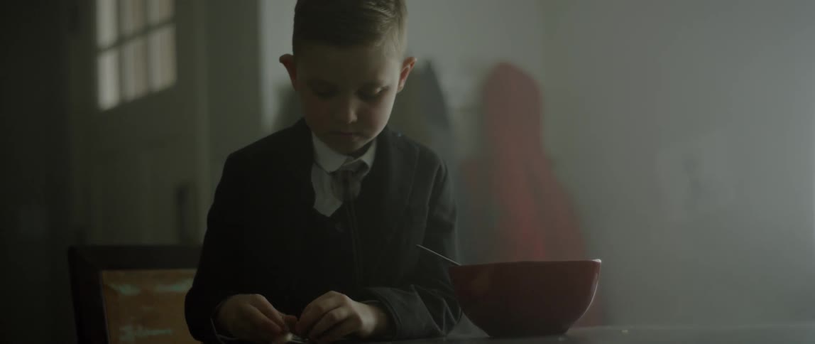 Child plays with a toy at a table next to a bowl