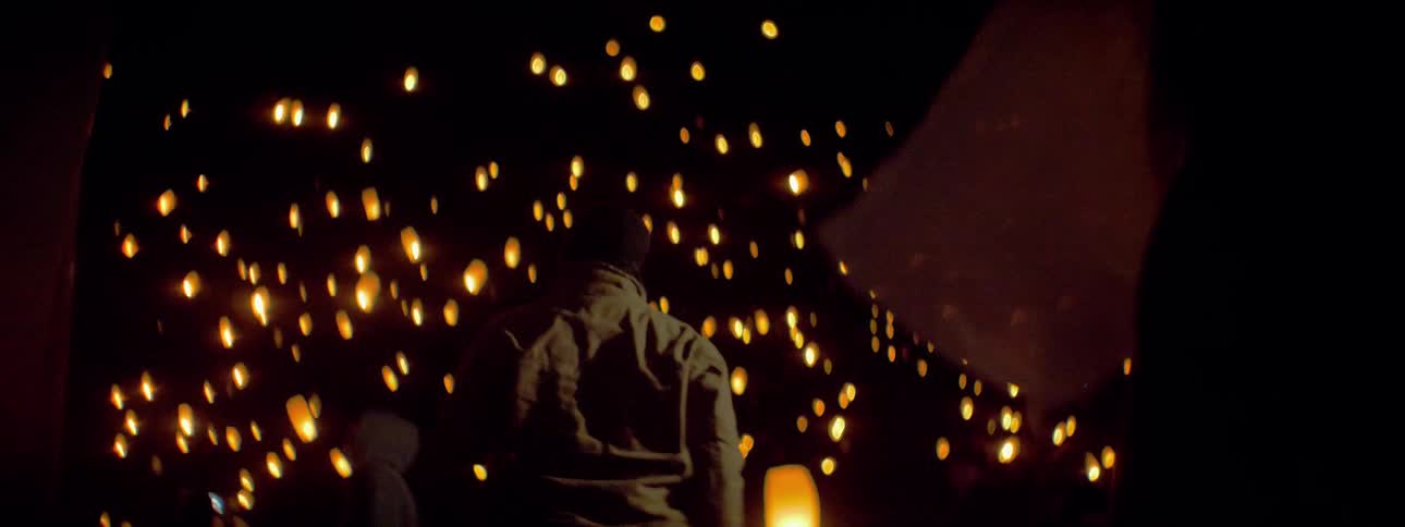A man releases lanterns into the sky