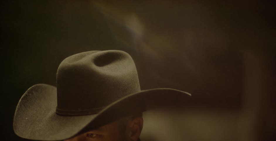 A man is wearing a cowboy hat
