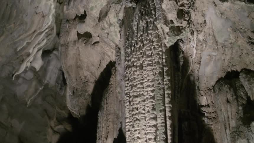 Water drips from rock formations in a cave