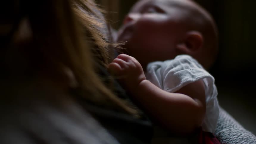 A woman holds a small baby