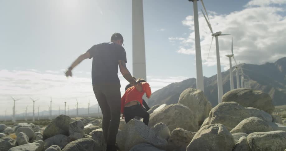 A man and his children play on some rocks