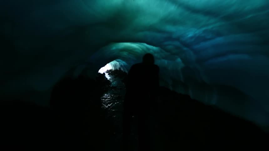 Person runs through a cave out to the sunlight