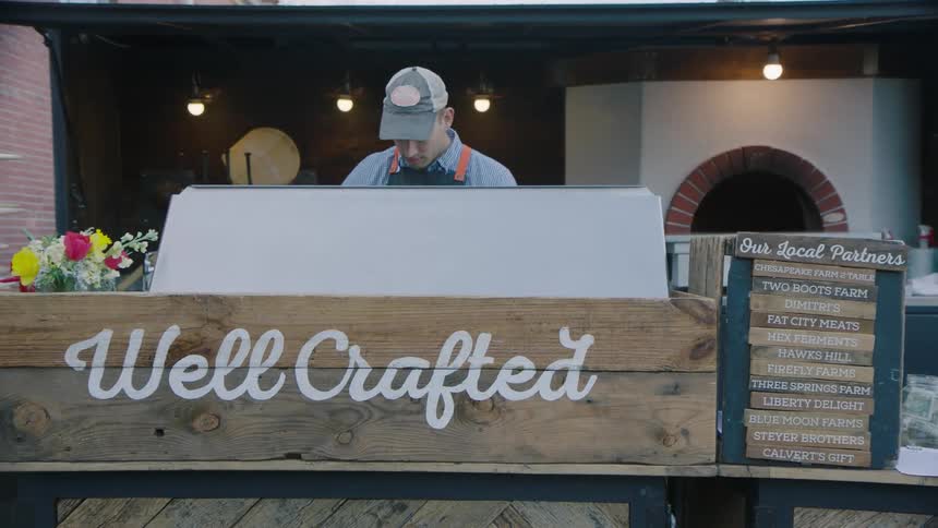 A chef is working in a restaurant outside during the day