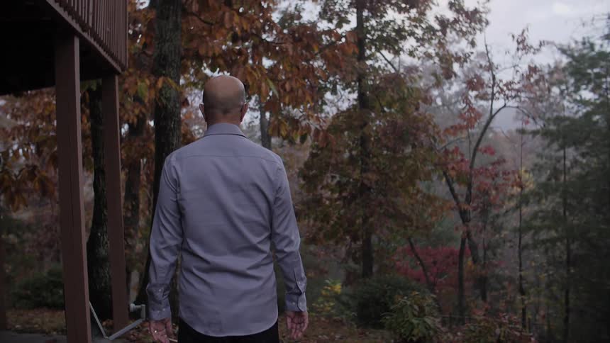 A man walks towards autumn trees