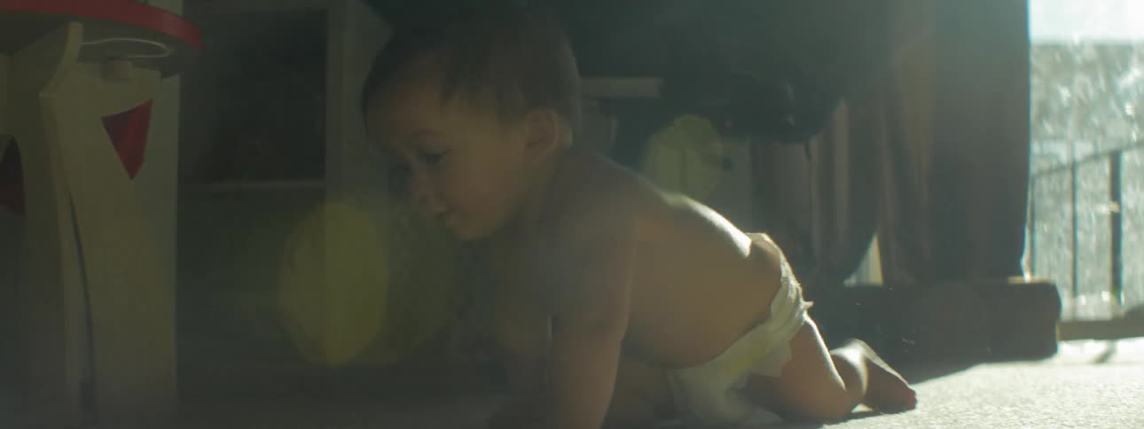 An infant crawls on the carpet